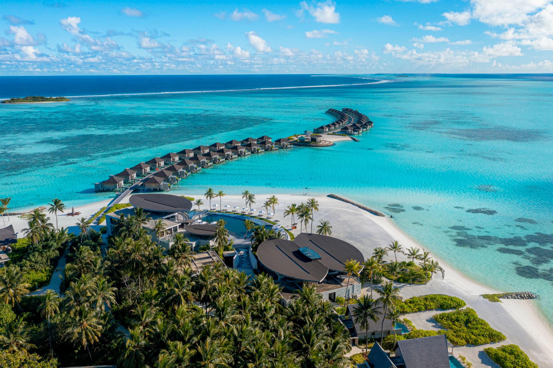 Aerial view of Madifushi Private Island's overwater villas and lagoon